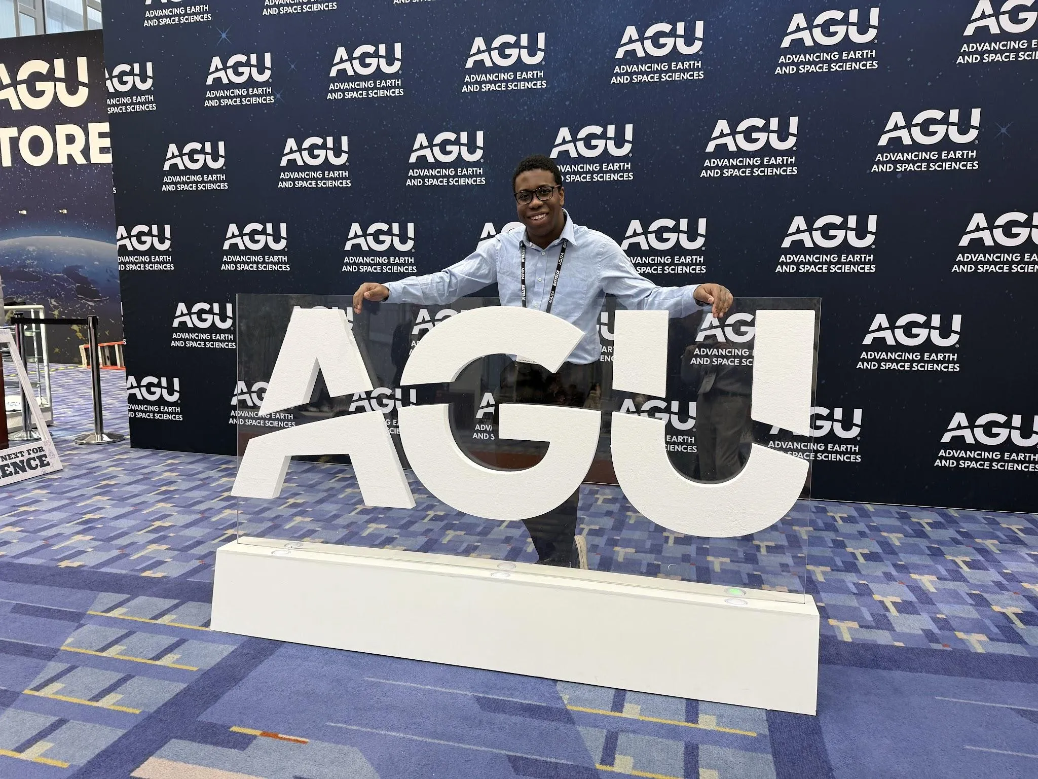 Samuel at the AGU 2024 sign.