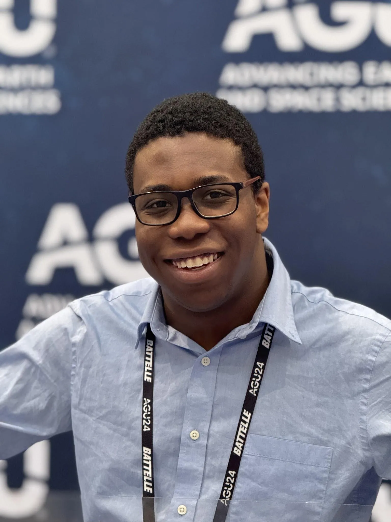 Close up of Samuel at the AGU 2024 sign.